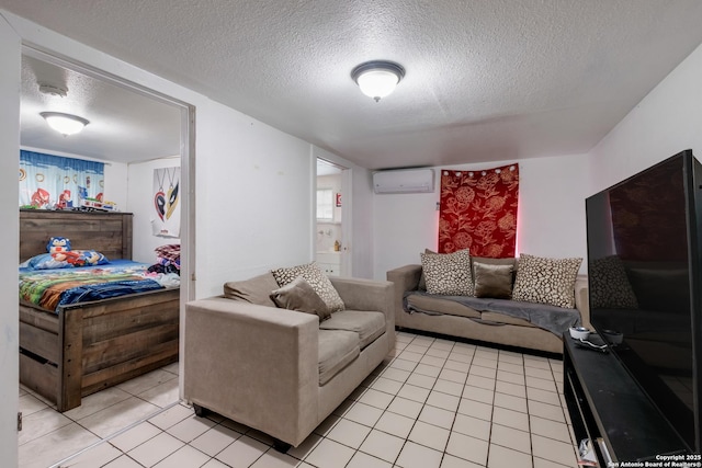 living area featuring an AC wall unit, a textured ceiling, and light tile patterned floors