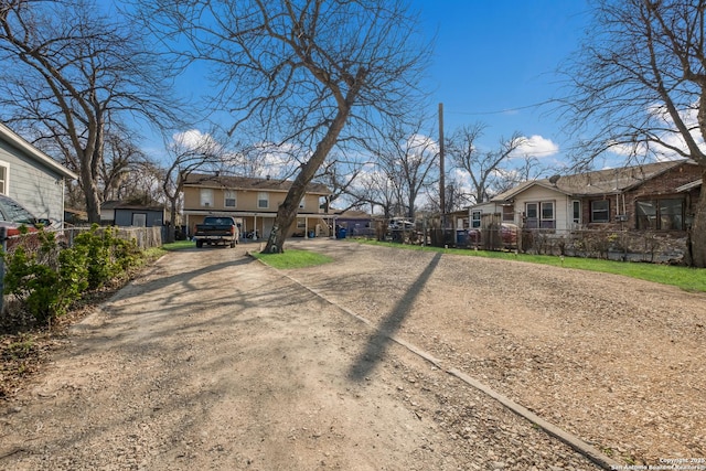 view of yard with a residential view, driveway, and fence