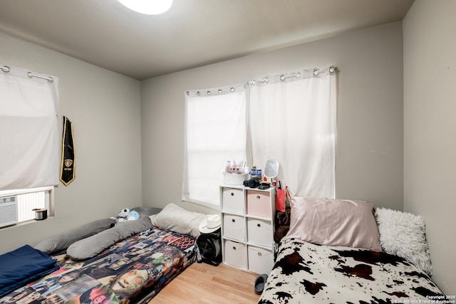 bedroom featuring light wood-style flooring and cooling unit