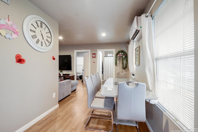 dining area with light wood-type flooring, baseboards, an AC wall unit, and recessed lighting