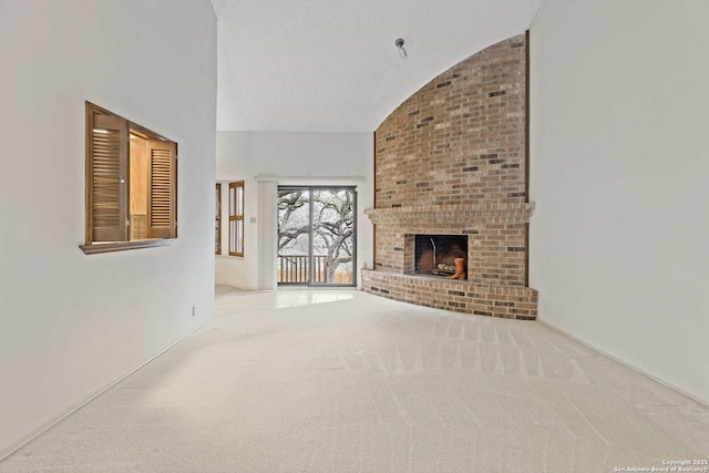 unfurnished living room with high vaulted ceiling, light carpet, a fireplace, and a textured ceiling