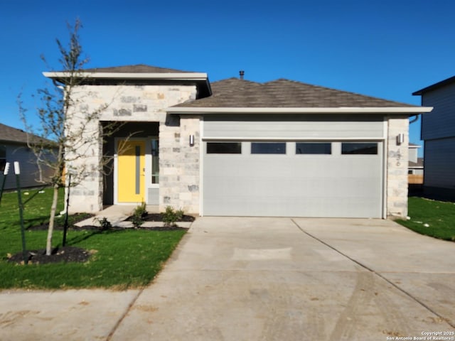 view of front facade featuring concrete driveway, stone siding, roof with shingles, an attached garage, and a front yard