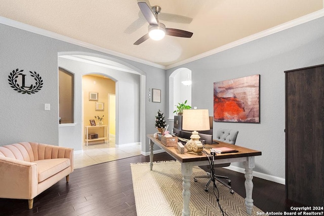 office space featuring baseboards, arched walkways, ceiling fan, ornamental molding, and wood finished floors