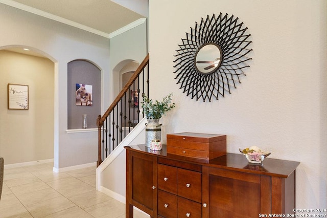 interior space with baseboards, tile patterned floors, and crown molding