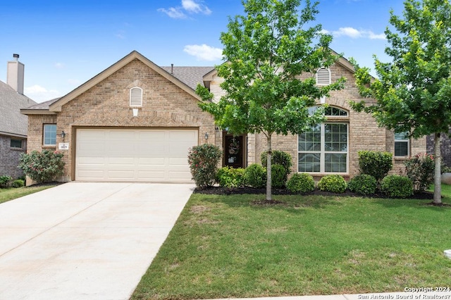 view of front of house featuring driveway, a shingled roof, an attached garage, a front lawn, and brick siding