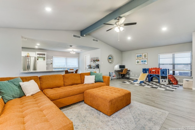 living area featuring a healthy amount of sunlight, visible vents, and wood finished floors