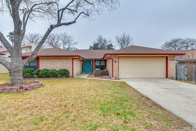 view of front of property with an attached garage, brick siding, fence, driveway, and a front yard