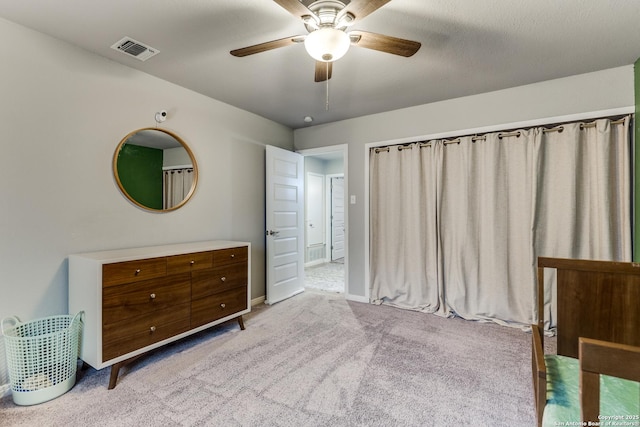 carpeted bedroom featuring baseboards, visible vents, and a ceiling fan