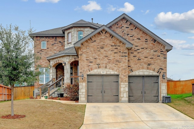 french country style house with concrete driveway, an attached garage, fence, a front lawn, and brick siding