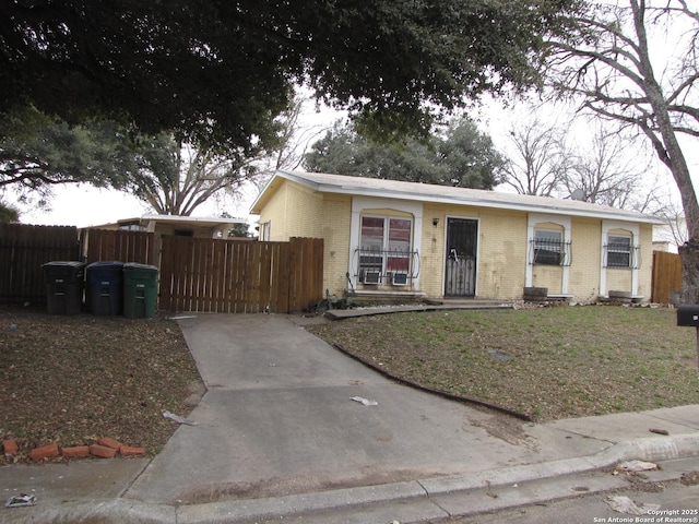 view of front of house featuring brick siding and fence