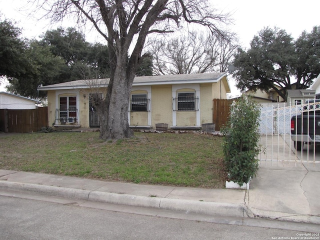 bungalow featuring a front yard, fence, and brick siding