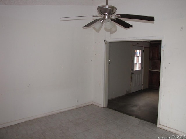 spare room with baseboards and a ceiling fan