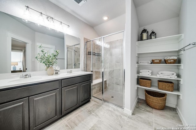 full bath with double vanity, a sink, visible vents, and a shower stall