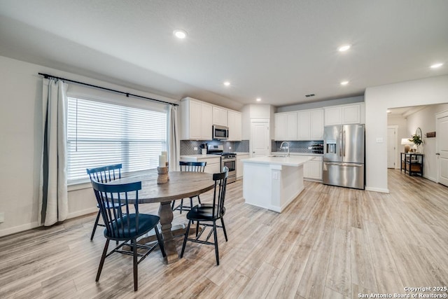 interior space featuring light wood-style floors, visible vents, baseboards, and recessed lighting