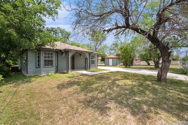 ranch-style home featuring driveway, a front yard, and an outdoor structure