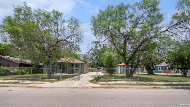 view of front of home with driveway, a fenced front yard, and a gate