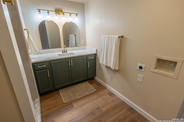 bathroom with baseboards, wood finished floors, and vanity