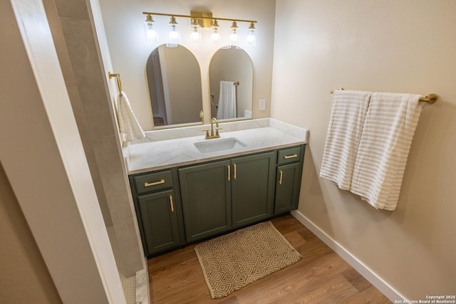 bathroom featuring wood finished floors, vanity, and baseboards