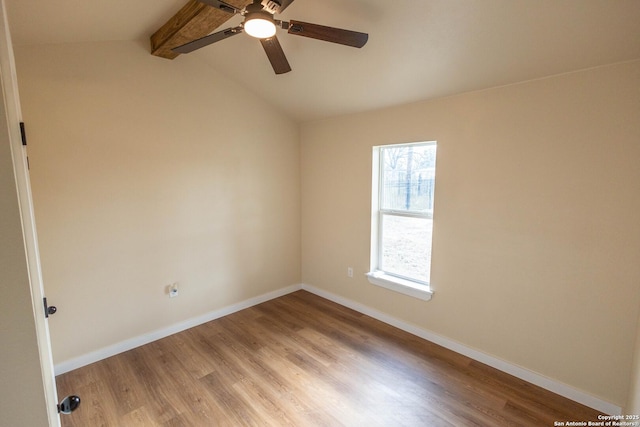 empty room with lofted ceiling with beams, ceiling fan, light wood finished floors, and baseboards