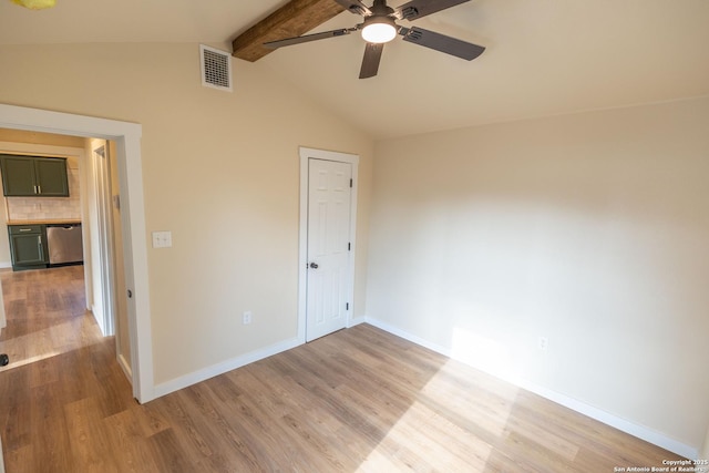 spare room featuring visible vents, light wood-style flooring, lofted ceiling with beams, a ceiling fan, and baseboards