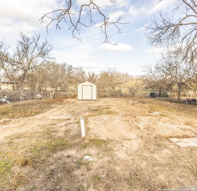 view of yard with a shed, fence, and an outbuilding