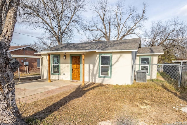 view of front of home featuring a patio area, fence, cooling unit, and stucco siding