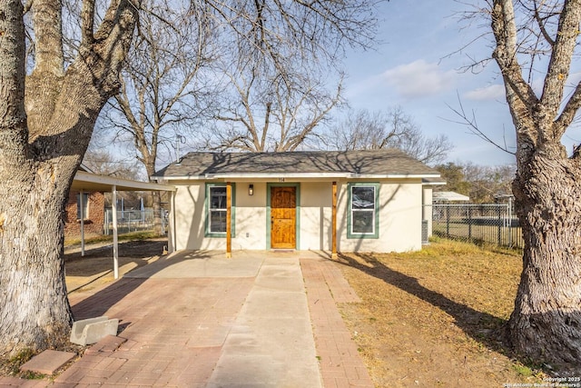 view of front of house featuring fence and stucco siding