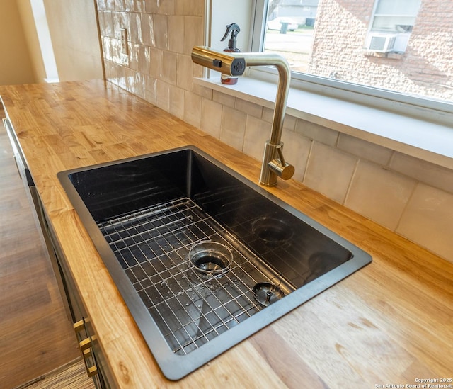 room details featuring cooling unit, a sink, and decorative backsplash