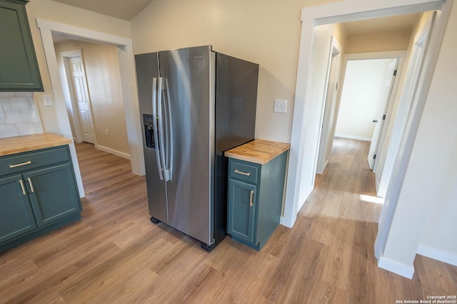 kitchen featuring light wood-style floors, wooden counters, and stainless steel fridge with ice dispenser