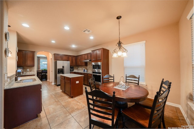 dining space featuring light tile patterned floors, visible vents, arched walkways, baseboards, and recessed lighting