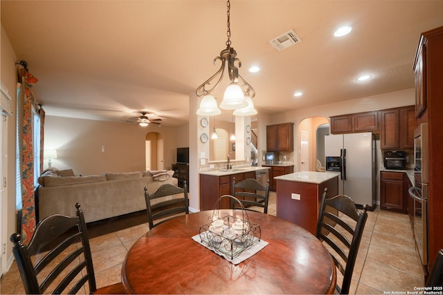 dining space featuring arched walkways, light tile patterned floors, recessed lighting, visible vents, and a ceiling fan