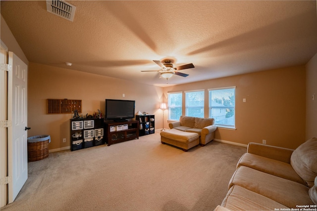 carpeted living area with baseboards, ceiling fan, visible vents, and a textured ceiling