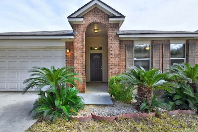 property entrance featuring a garage and brick siding