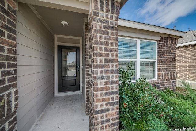 entrance to property featuring brick siding