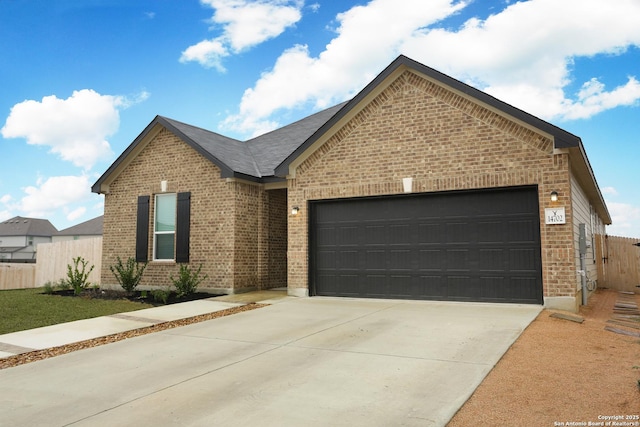 single story home with concrete driveway, brick siding, fence, and an attached garage