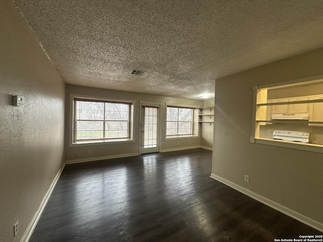 unfurnished living room featuring dark wood-style flooring, visible vents, a textured wall, a textured ceiling, and baseboards