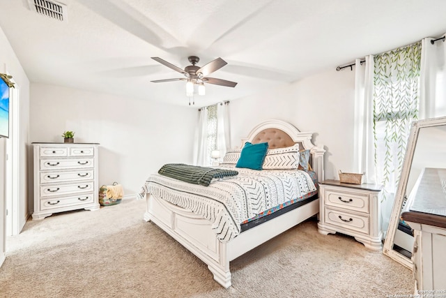 bedroom with a ceiling fan, visible vents, and light colored carpet