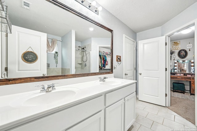 full bath featuring double vanity, a stall shower, visible vents, and a sink