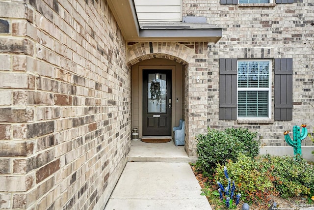 view of exterior entry with brick siding