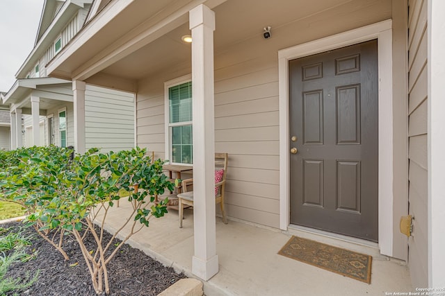 view of exterior entry with a porch