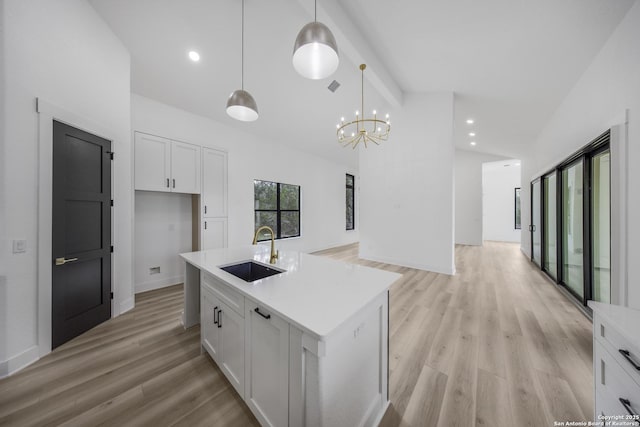 31047 Windmill Ln, Bulverde, TX 78163 - kitchen with a sink, vaulted ceiling, white cabinets, open floor plan, and light wood-type flooring