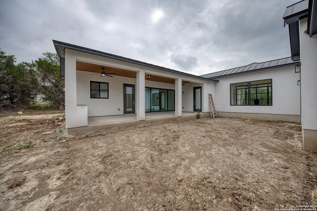 31047 Windmill Ln, Bulverde, TX 78163 - back of house featuring a standing seam roof, ceiling fan, stucco siding, a patio area, and metal roof