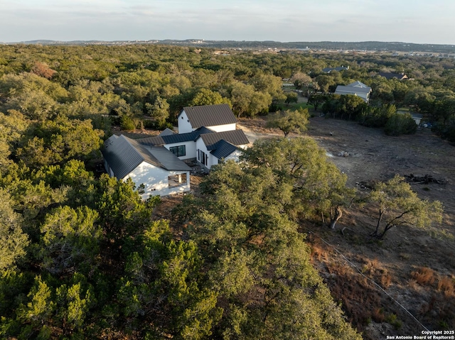 bird's eye view with a wooded view