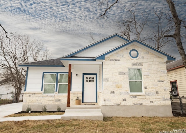 view of front of property featuring stone siding and a shingled roof