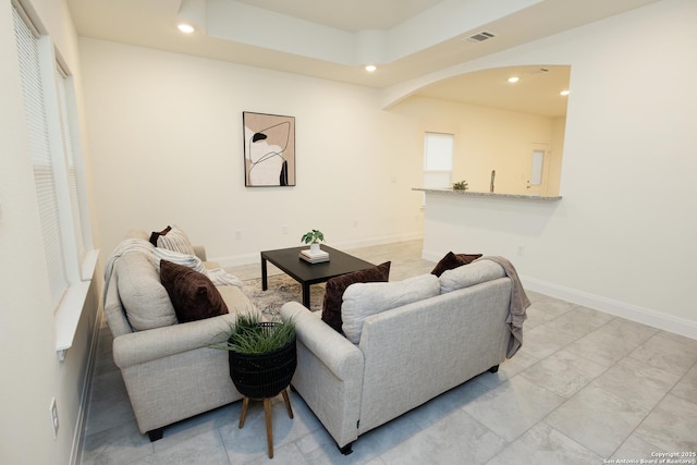 living room with baseboards, visible vents, arched walkways, and recessed lighting