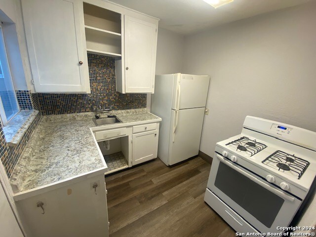 kitchen with open shelves, white appliances, white cabinetry, and light countertops