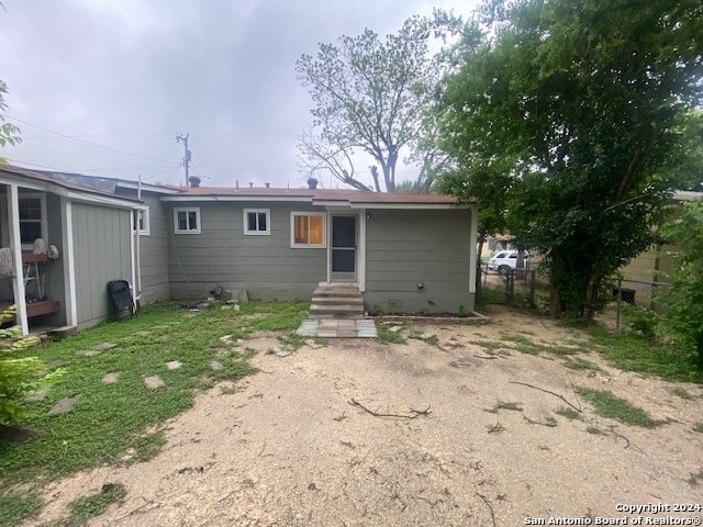rear view of property featuring fence