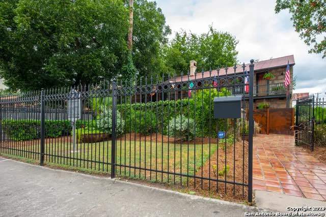 view of gate with a lawn and fence