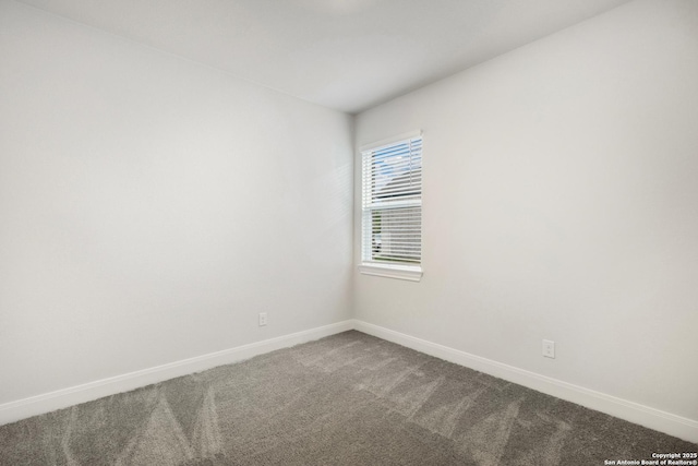 spare room featuring carpet floors and baseboards