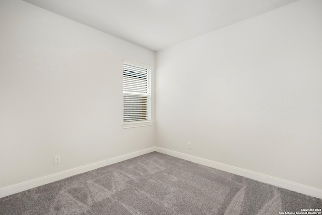 carpeted spare room featuring baseboards